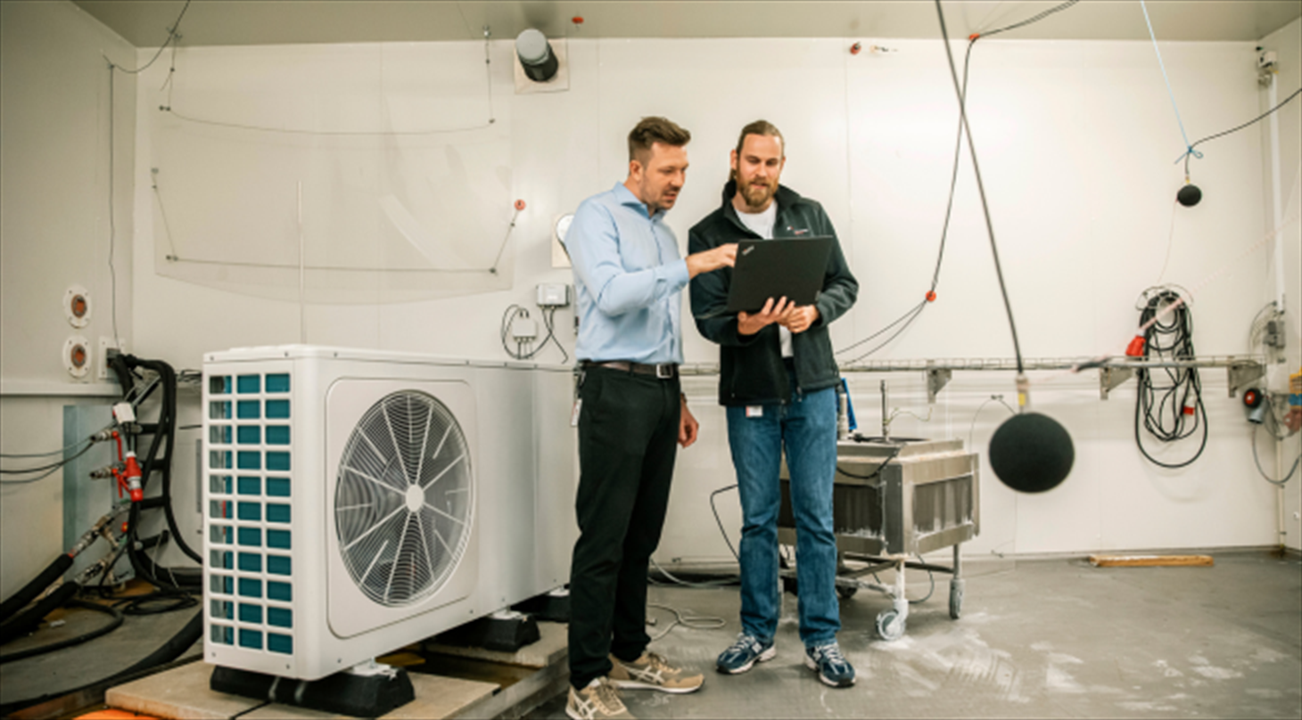 Two test engineers looking at a computer inside a climate chamber in the Heat Pump Test Laboratory at Danish Technological Institute